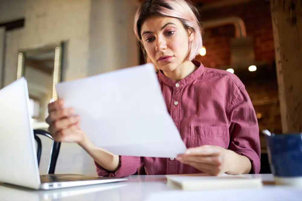 woman looking at he roof insurance claim paperworks 