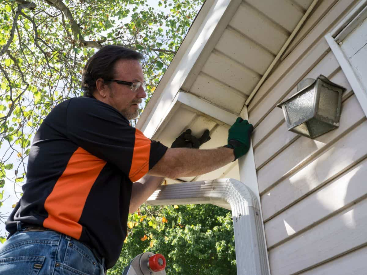 Contractor popping vinyl siding back in place