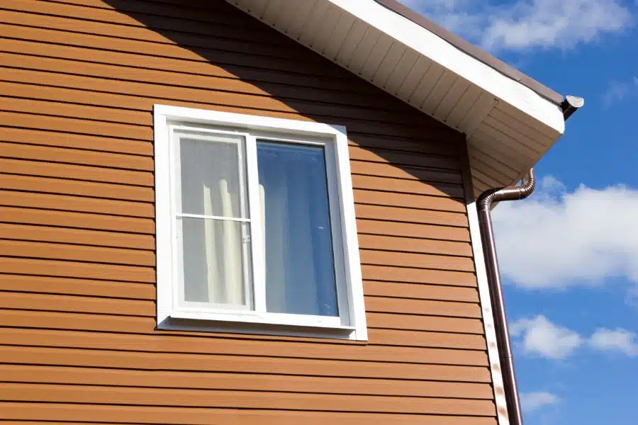 window in wall of brown vinyl siding