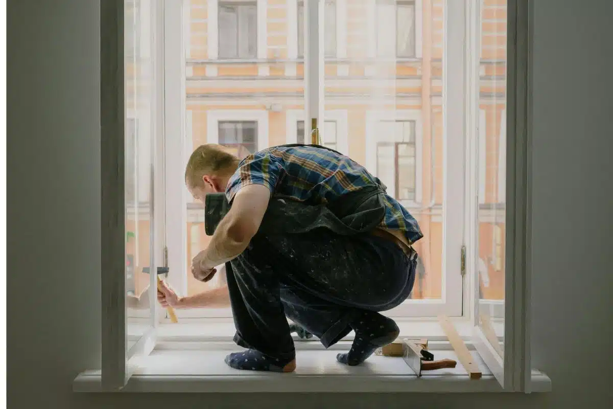 Anonymous man on windowsill during repair work