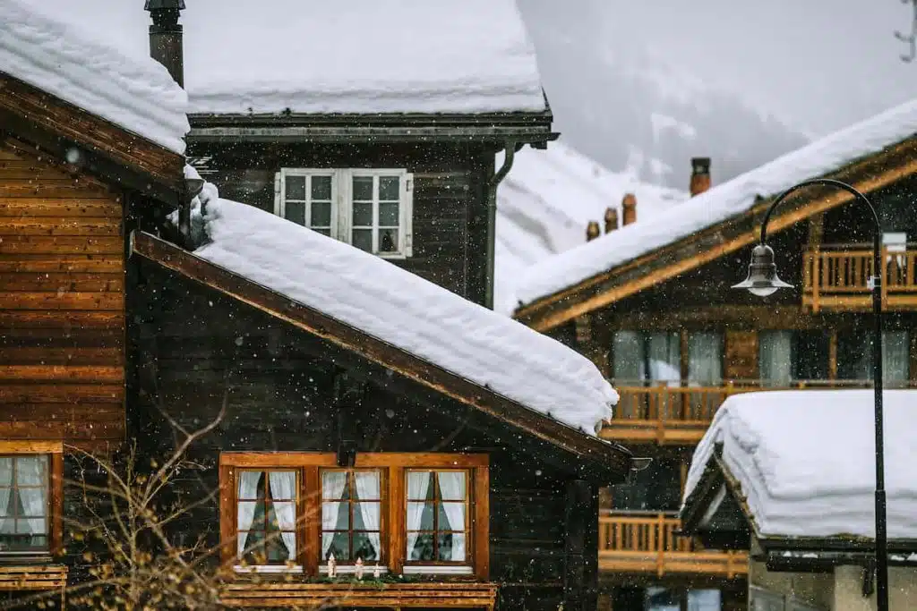 Wooden houses covered with snow in mountainous valley in winter